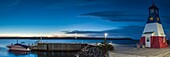Kanada, Nova Scotia, Cabot Trail, Cheticamp, Stadthafen mit Leuchtturm in den traditionellen Farben der Akadier, Abenddämmerung