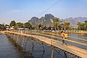 Laos, Provinz Vientiane, Vang Vieng, Hängebrücke über den Nam Song-Fluss, im Hintergrund das Karstgebirge