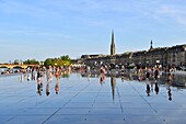 France, Gironde, Bordeaux, area listed as World Heritage by UNESCO, Saint Pierre district, Place de la Bourse, the reflecting pool from 2006 and directed by Jean-Max Llorca hydrant and Saint Michel basilica in the background