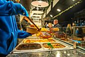 Blick auf einen Essensstand auf dem Weihnachtsmarkt in der St. Georges Hall, Liverpool City Centre, Liverpool, Merseyside, England, Vereinigtes Königreich, Europa