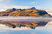 Berge und Rorbuer spiegeln sich in einem Fjord während des Sonnenuntergangs, Leknes, Vestvagoy, Nordland, Lofoten, Norwegen, Skandinavien, Europa