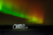 A crashed DC-3 aircraft under the Northern Lights (Aurora Borealis), Iceland, Polar Regions