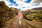 Woman walking along trails, Sacred Valley, Peru, South America