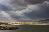 Usa, New Mexico, Abiquiu, Sonne scheint durch Gewitterwolken über dem Abiquiu-See