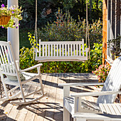 Rocking chair and swing on front porch of cottage house