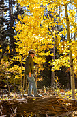 USA, New Mexico, Junge geht auf Baumstamm im Santa Fe National Forest