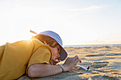 Mexiko, Baja, Pescadero, Junge spielt mit Spielzeugflugzeug am Strand