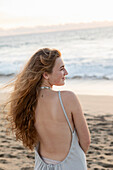 Mexiko, Baja, Pescadero, Rückansicht eines Mädchens im Teenageralter am Strand bei Sonnenuntergang