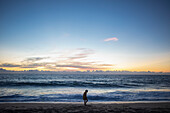 Mexico, Baja, Pescadero, Silhouette of boy on beach at dusk