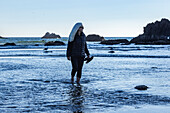 USA, Oregon, Frau watet im Meer am Cannon Beach