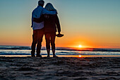 Rückansicht eines Paares am Cannon Beach bei Sonnenuntergang