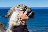 Seitenansicht einer älteren Frau mit langen Haaren, die nach oben schaut