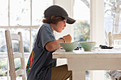 Boy (10-11) playing at dining table