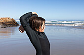 Boy (10-11) stretching on Kammabaai Beach