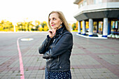 Porträt einer nachdenklichen Frau, die vor einem Gebäude steht
