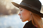 Portrait of young woman in hat on sunny day
