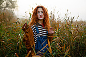 Portrait of serious woman walking in field at dawn