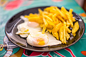 French Fries and Sunny-Side Up Eggs on a Plate