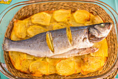 Baked Sea Bass With Potatoes on Vibrant Turquoise Tablecloth