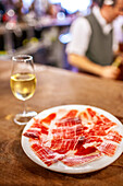 Ein Glas Fino und iberischer Schinken in einer Taverne in Sevilla