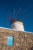 Eine traditionelle Windmühle hinter einer Steinmauer. Chora, Insel Mykonos, Kykladen-Inseln, Griechenland.