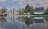 Ireland, Cork, Gougane Barra. Church and mountain reflections in lake.