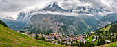 Europe, Switzerland, Bernese Oberland. Panoramic of mountains and village in valley.