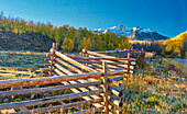 USA, Colorado, Quray. Dallas Divide, Sonnenaufgang auf dem Mt. Snaffles mit Herbstfarben und Split Rail Zaun