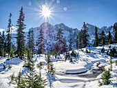 USA, Bundesstaat Washington, Alpine Lakes Wilderness. Gefrorener Alpenteich mit Neuschnee und Cascade Range