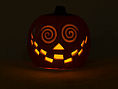 USA, Washington State. Smiling Jack O Lantern face on Pumpkin at Halloween, at night