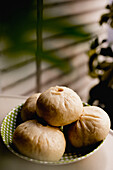 Pile of steamed baozi buns on ceramic plate
