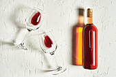 Draufsicht auf ein Arrangement von feinem Rotwein, der auf einer rissigen Oberfläche inmitten von Weingläsern liegt