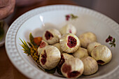 Ripe figs with juicy pulp in ceramic plate with ornament in house on blurred background