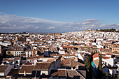 Cityscape with typical old residential houses located on streets against cloudy blue sky on sunny day in Antequera city