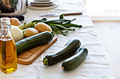 Hoher Blickwinkel auf verschiedene frische Zutaten, die für die Zubereitung einer appetitlichen Zucchinicremesuppe zu Hause vorbereitet werden