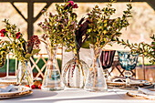 Nahaufnahme von transparenten Glasvasen mit frischen Blumensträußen auf dem Tisch für eine Veranstaltung