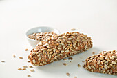High angle of loaves of fresh yummy sunflower seed bread placed on white background in bakery