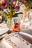 High angle of served festive table with crystal glasses cutlery napkin on plate near bunch of fresh flowers for wedding and menu card
