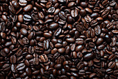 Draufsicht auf eine Kulisse, die Hälften von dunkelbraunen, angenehm duftenden Kaffeebohnen darstellt