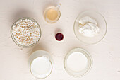 Top view of various ingredients for preparing white hot chocolate arranged on white background in studio