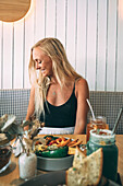 Blond woman looking to the side sitting in a restaurant