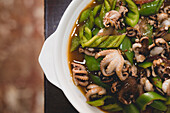 Schüssel mit traditionellen, appetitanregenden, würzigen Ramen auf Holztisch in asiatischem Restaurant