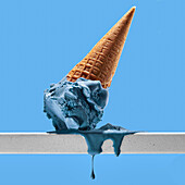 Appetitliches geschmolzenes blaues Eis mit Waffeltüte auf weißem Geländer vor hellem wolkenlosen Himmel