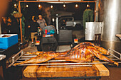 Leckeres gegrilltes Lammfleisch mit knuspriger Kruste auf einem Metallgestell in einem hellen Café während des Garvorgangs