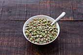 Top view of frozen broad beans in bowl served on rustic wooden table