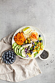 Draufsicht auf Teller mit köstlichen frischen Apfel- und Limettenscheiben neben Süßkartoffelspalten und Oliven mit Hummus auf dem Tisch