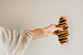 Hands of woman with bright pink manicure holding tasty baked azuki bun on grey background