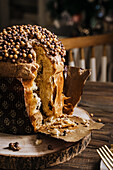 Sweet homemade baked panettone on round wooden stand for celebrating Christmas