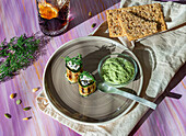 Leckere gebratene Zucchiniröllchen mit Füllung, serviert neben Püree mit Dill auf dem Tisch mit kaltem Erfrischungsgetränk