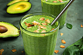Glasses with healthy green smoothie made with avocado spinach and mint leaves